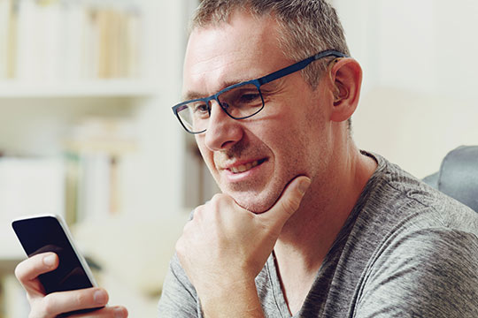 Man looking at hearing aids on his phone